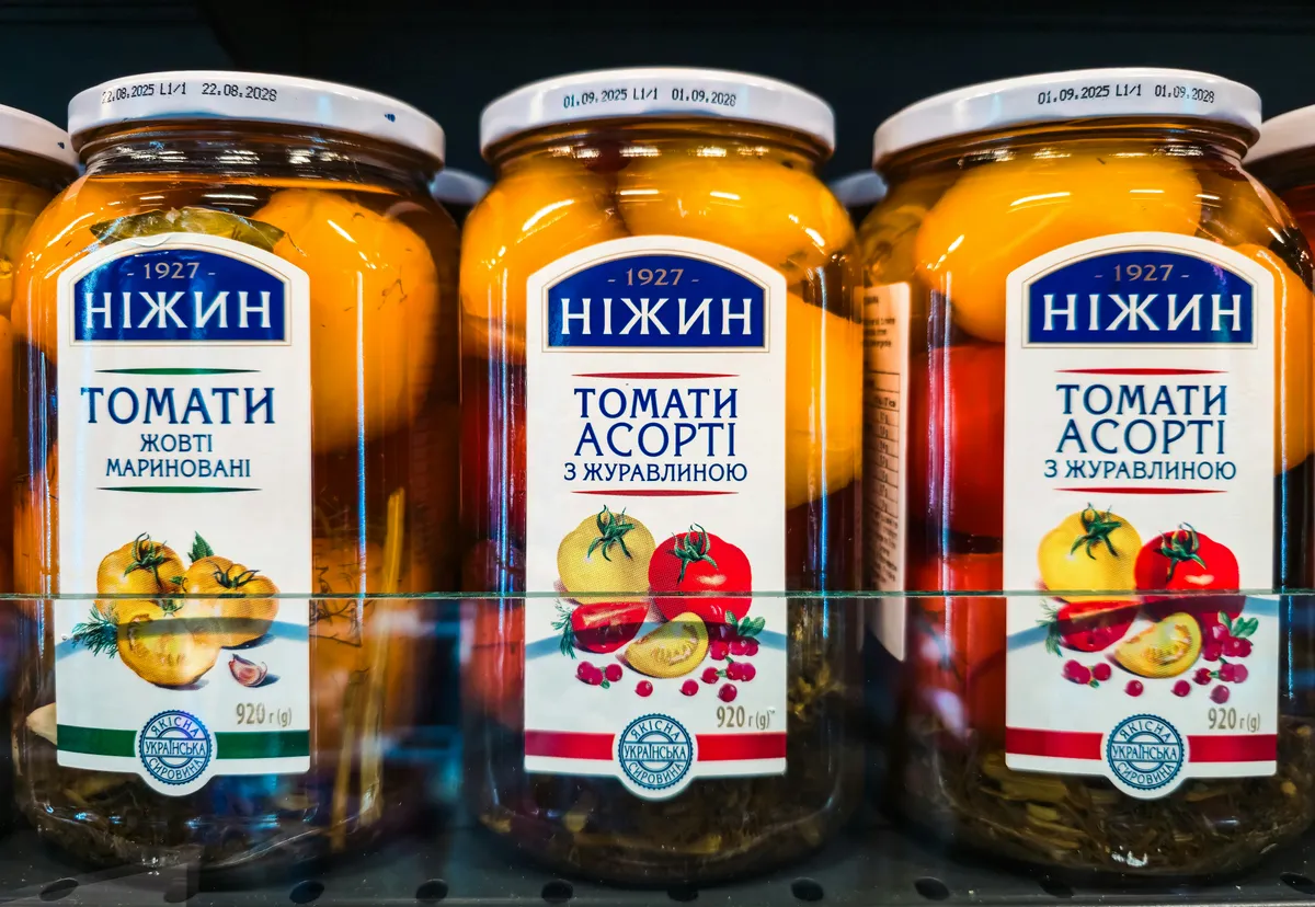 Glass food jars with printed wrap labels on a store shelf