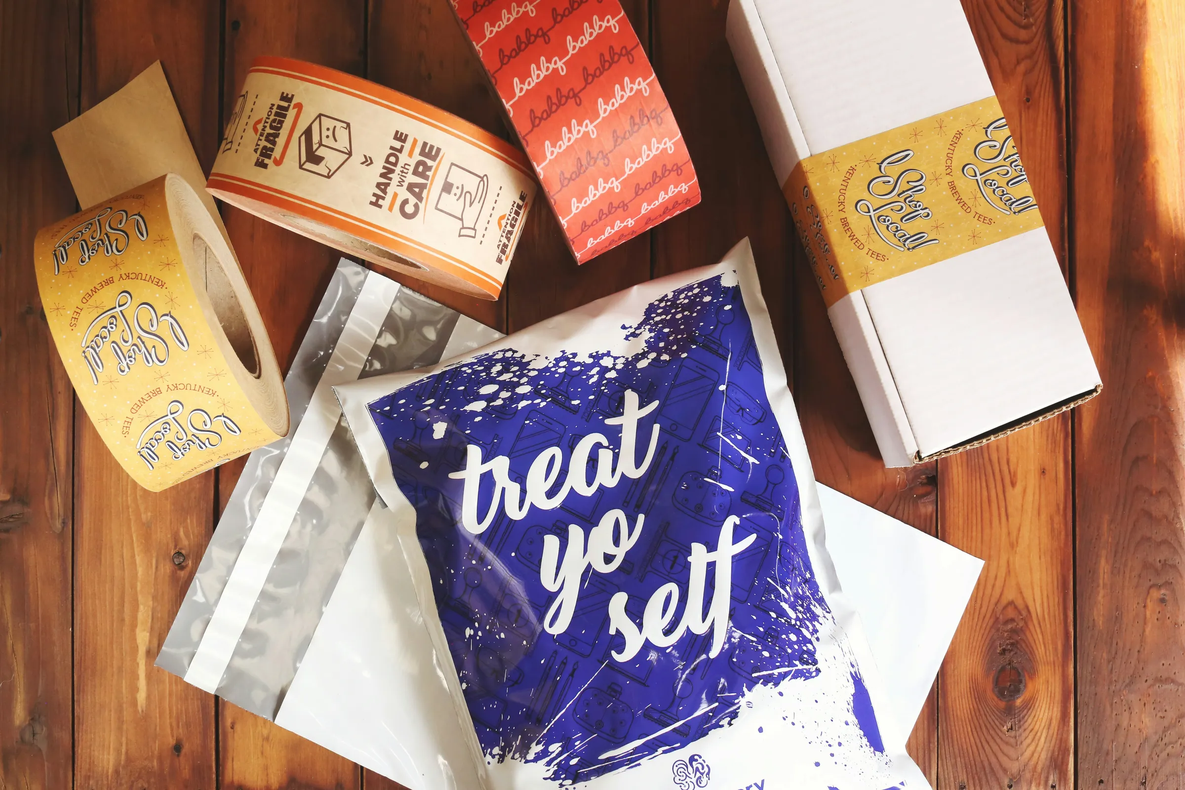 Printed poly mailer bag with custom printed packing tapes and a sleeved box
