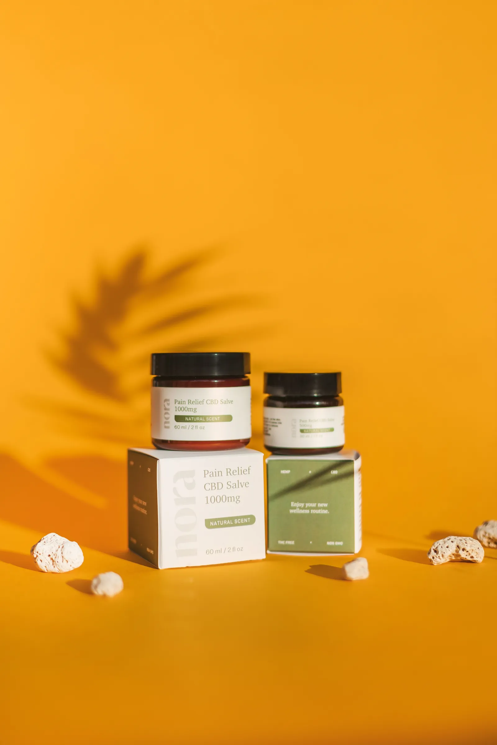 Salve jars with labels on matching cartons against an orange background
