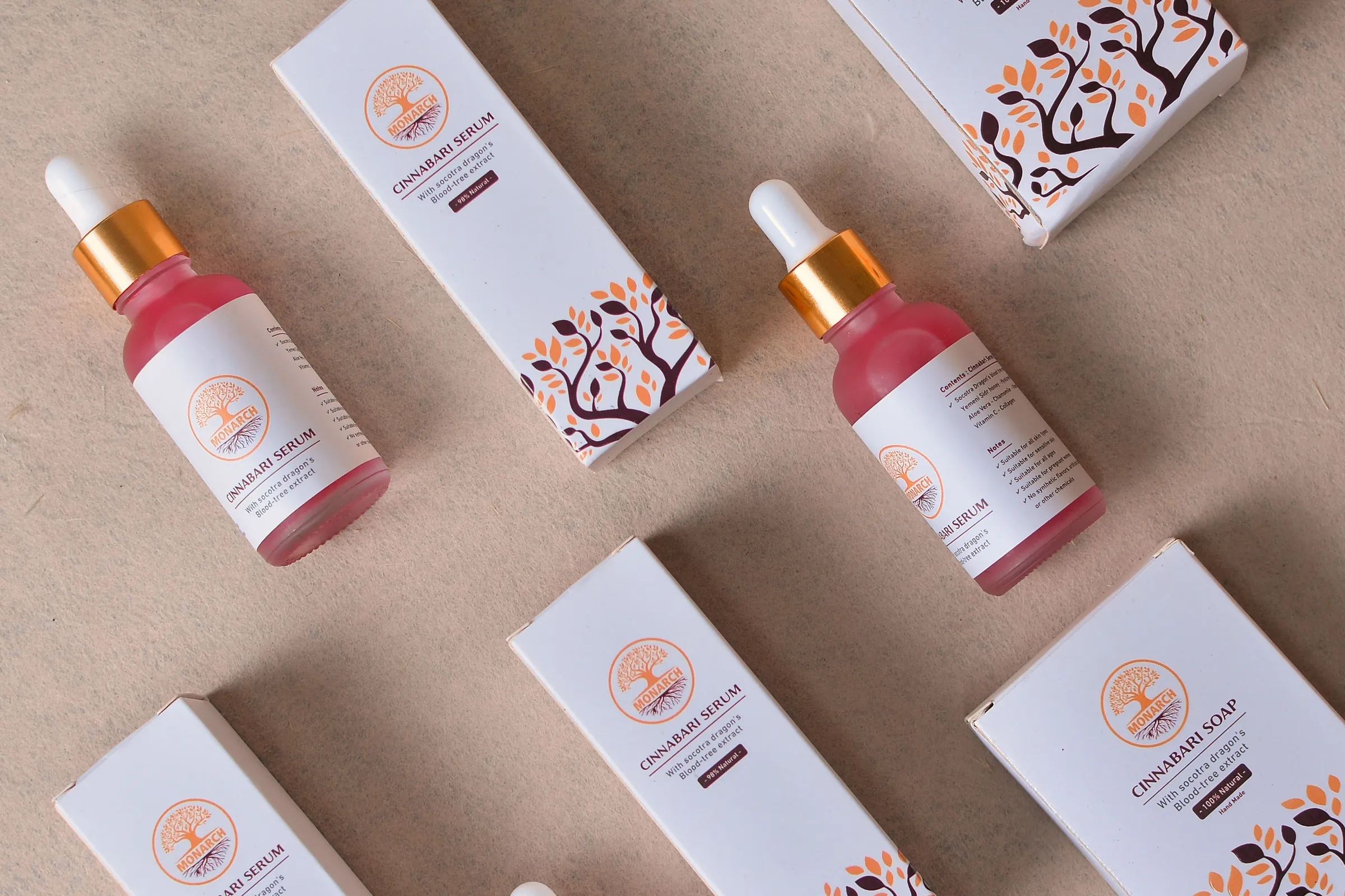 Serum dropper bottles beside white folding cartons printed with an orange tree illustration