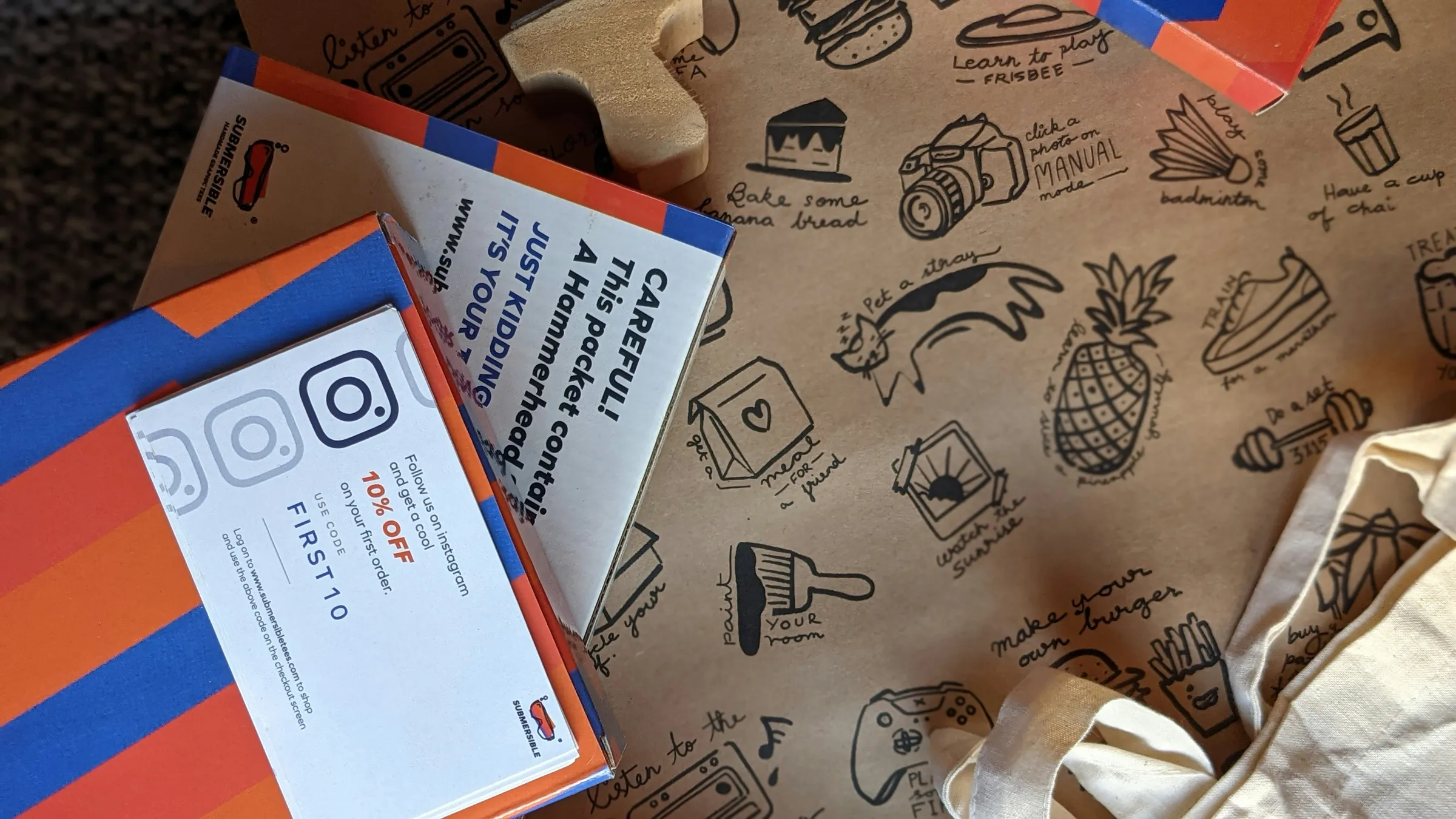 E-commerce unboxing: printed kraft wrap, striped mailer and insert cards laid out flat